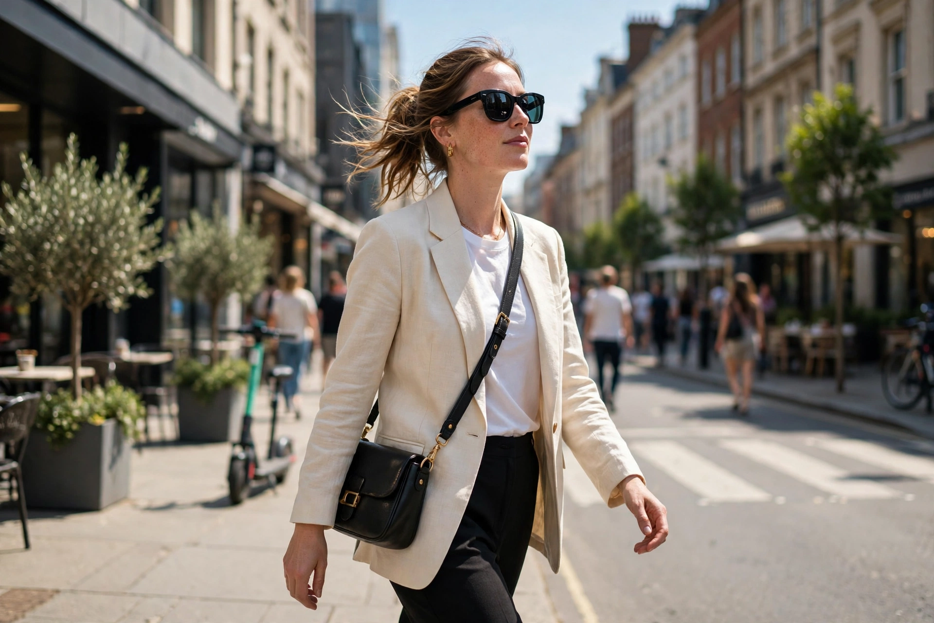 Confident woman in sunglasses walking through a sunny city street